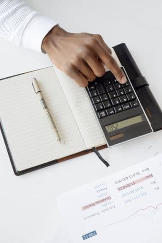 Calculadora y hoja con tipos de cambio sobre un escritorio